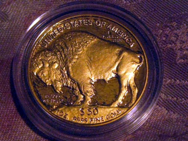 Eine gold- und braune Münze mit der Aufschrift "The United States Of America" darauf, auf einem braunen Teppichhintergrund platziert.