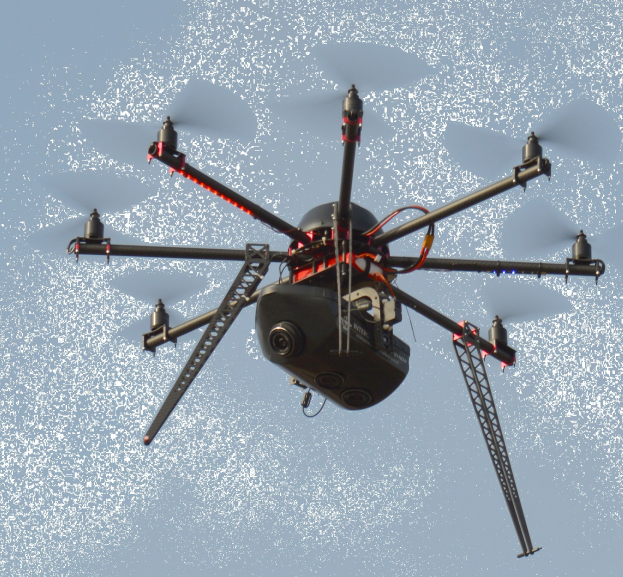 Eine schwarze Drohne mit einer Kamera, die durch die Luft fliegt.