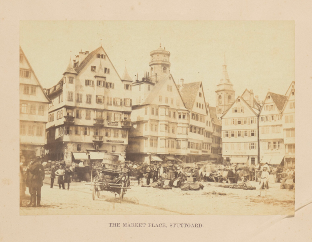 Ein altes Foto eines belebten Marktes in Stuttgart, Deutschland, mit zahlreichen Gebäuden, Menschen, Karren und verschiedenen Gegenständen, das eine Inschrift am unteren Bildrand zeigt.