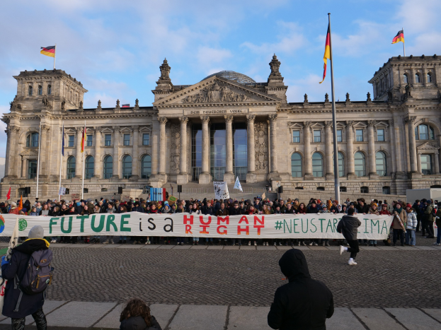 Gruppe von Menschen vor dem Reichstagsgebäude in Berlin mit einem Banner mit der Aufschrift "Zukunft ist ein Human Neustar ima."