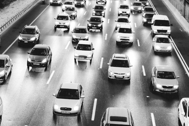 Autos auf einer Straße in einem Schwarz-Weiß-Bild.