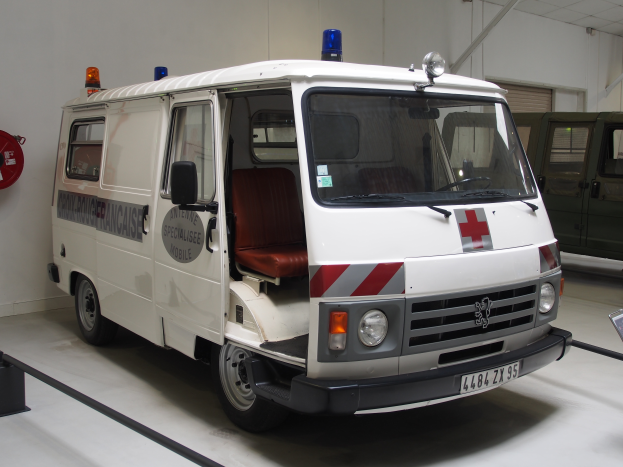 Ein Rettungswagen steht in einem Gebäude geparkt, mit einem Feuerlöscher an der Wand links.