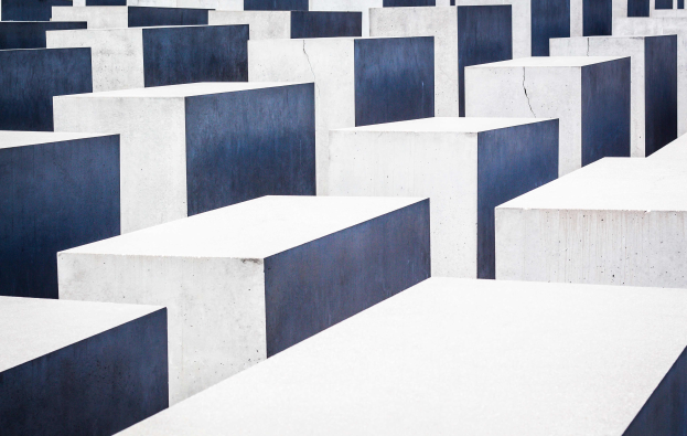 Ein Feld aus Betonplatten in verschiedenen Höhen, die in einem Gittermuster angeordnet sind, bekannt als das Holocaust-Mahnmal für die ermordeten Juden Europas in Berlin, Deutschland.