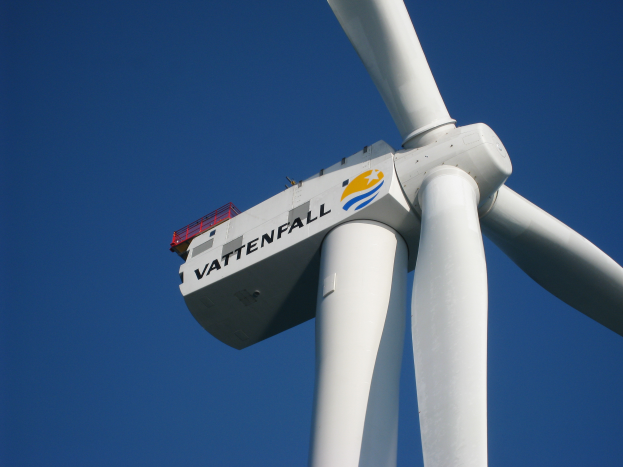 Eine weiße Windkraftanlage mit dem Wort "Vattenfall" darauf, vor einem hellblauen Himmel.