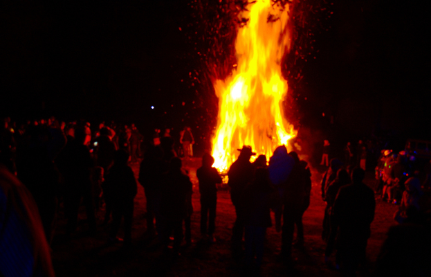 Eine Gruppe von Menschen, die vor einem Feuer steht.
