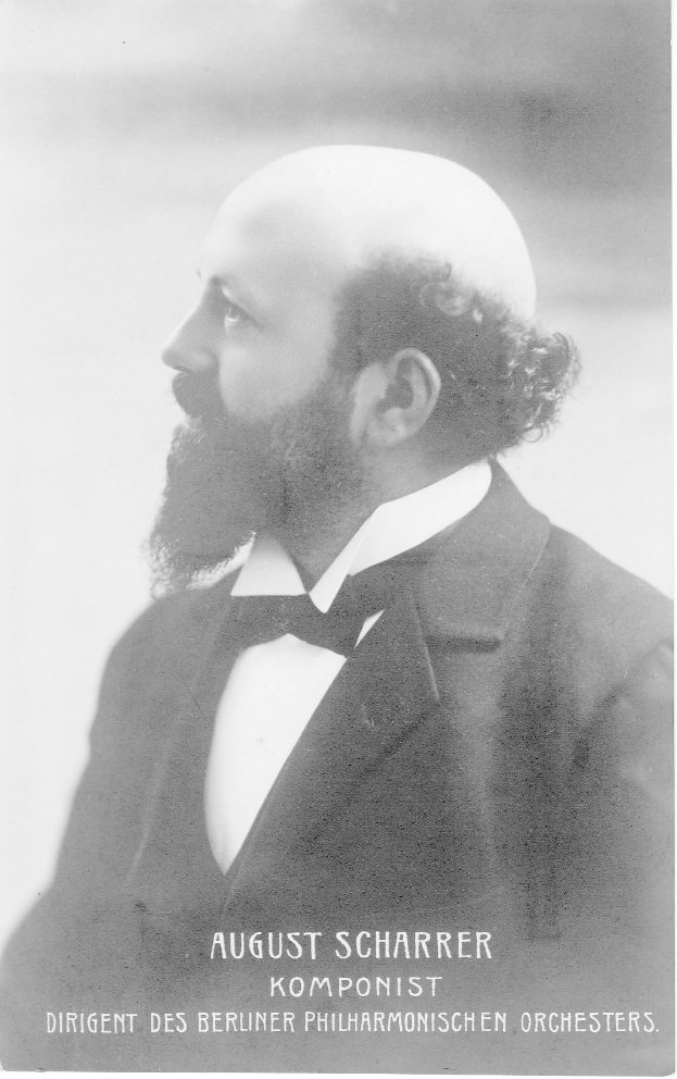 Ein Schwarz-Wei├č-Foto von August Scharrer, einem deutschen Komponisten, der einen Blazer und eine Krawatte tr├Ągt, mit Text am unteren Rand des Bildes.