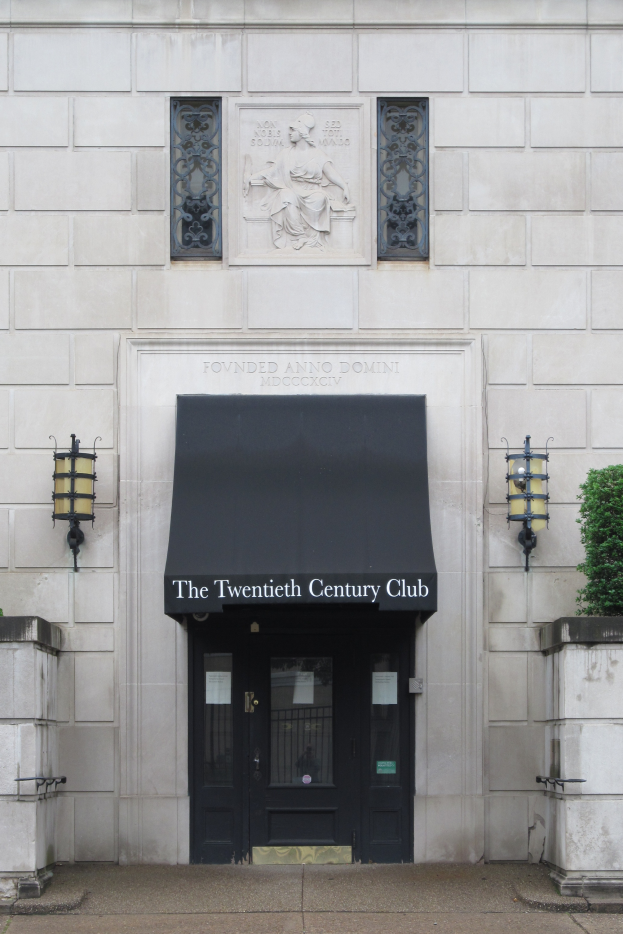 Der Club des 20. Jahrhunderts in London, England, mit einem Gebäude mit Fenstern, einer Tür, einer Texttafel, Wandlampen, einer Pflanze auf der rechten Seite und einem Weg unten.