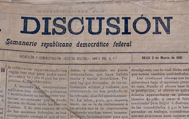 Eine gelbliche, leicht zerknitterte Zeitung mit der schwarzen Schrift 'Diskussion' darauf, die die Schlagzeile 'Semanario Republicano Democrático Federal' trägt.