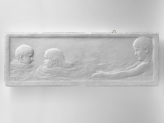 Schwarzes und weißes Foto von drei Kindern, die im Wasser schwimmen, mit einer Wand im Hintergrund, wobei eines der Kinder in der Mitte des Pools zu sehen ist.